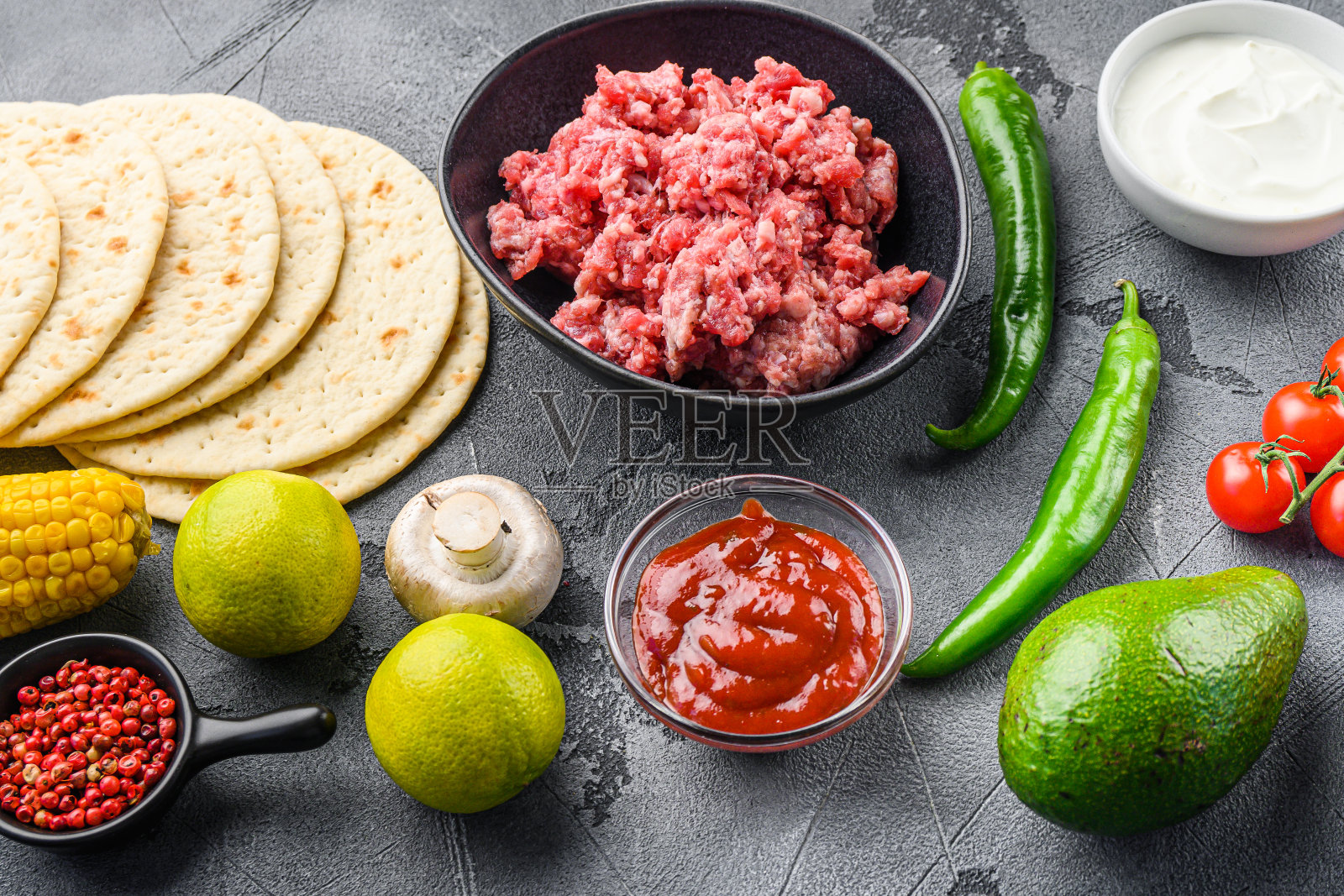 传统墨西哥玉米饼的食材与肉在灰色的背景，侧视图。照片摄影图片