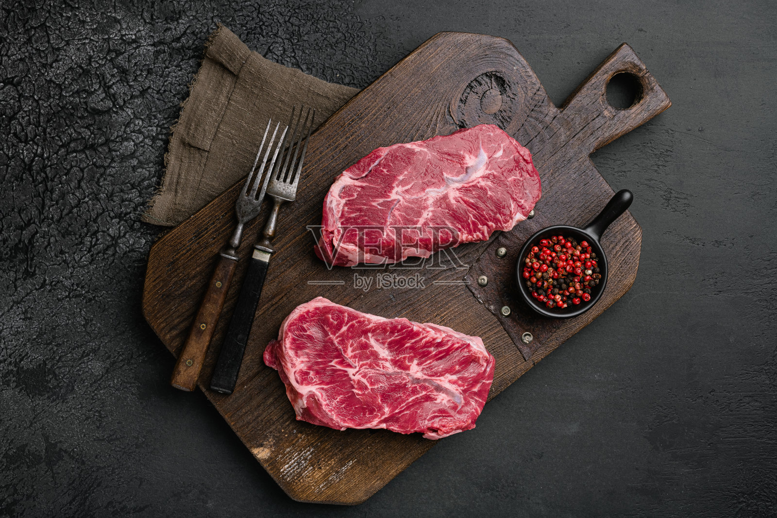 生刀片牛排，在黑色深色石桌背景，俯视图平铺照片摄影图片