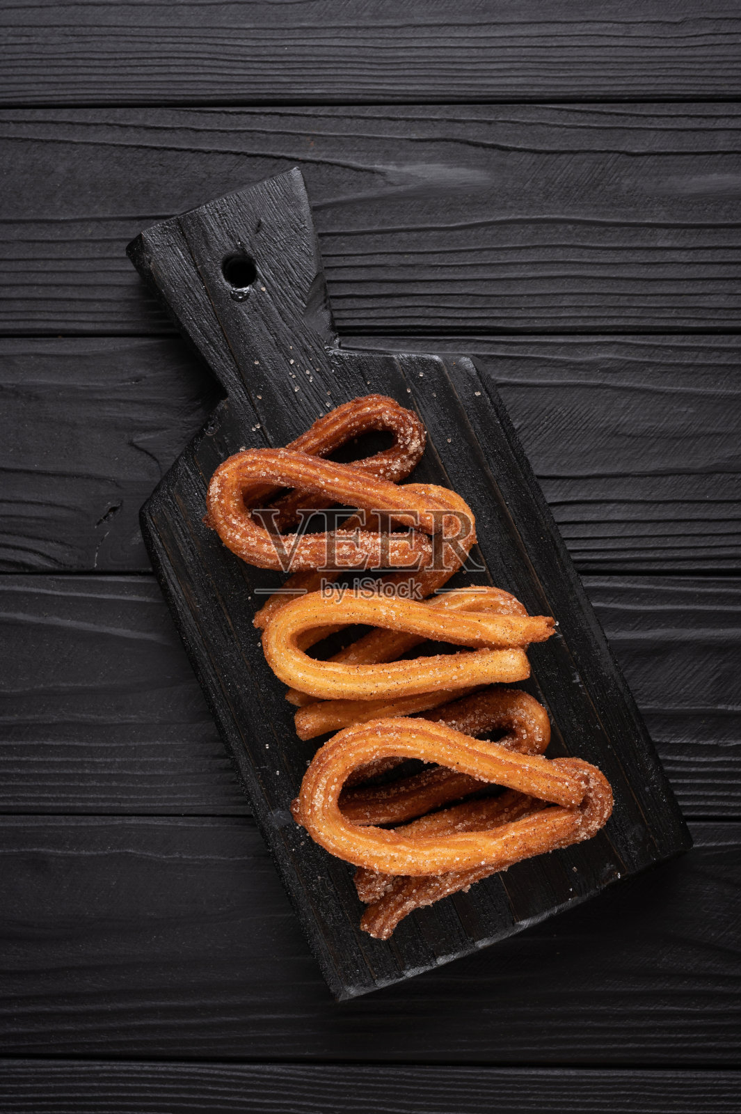 木制黑色背景自制油条。照片摄影图片