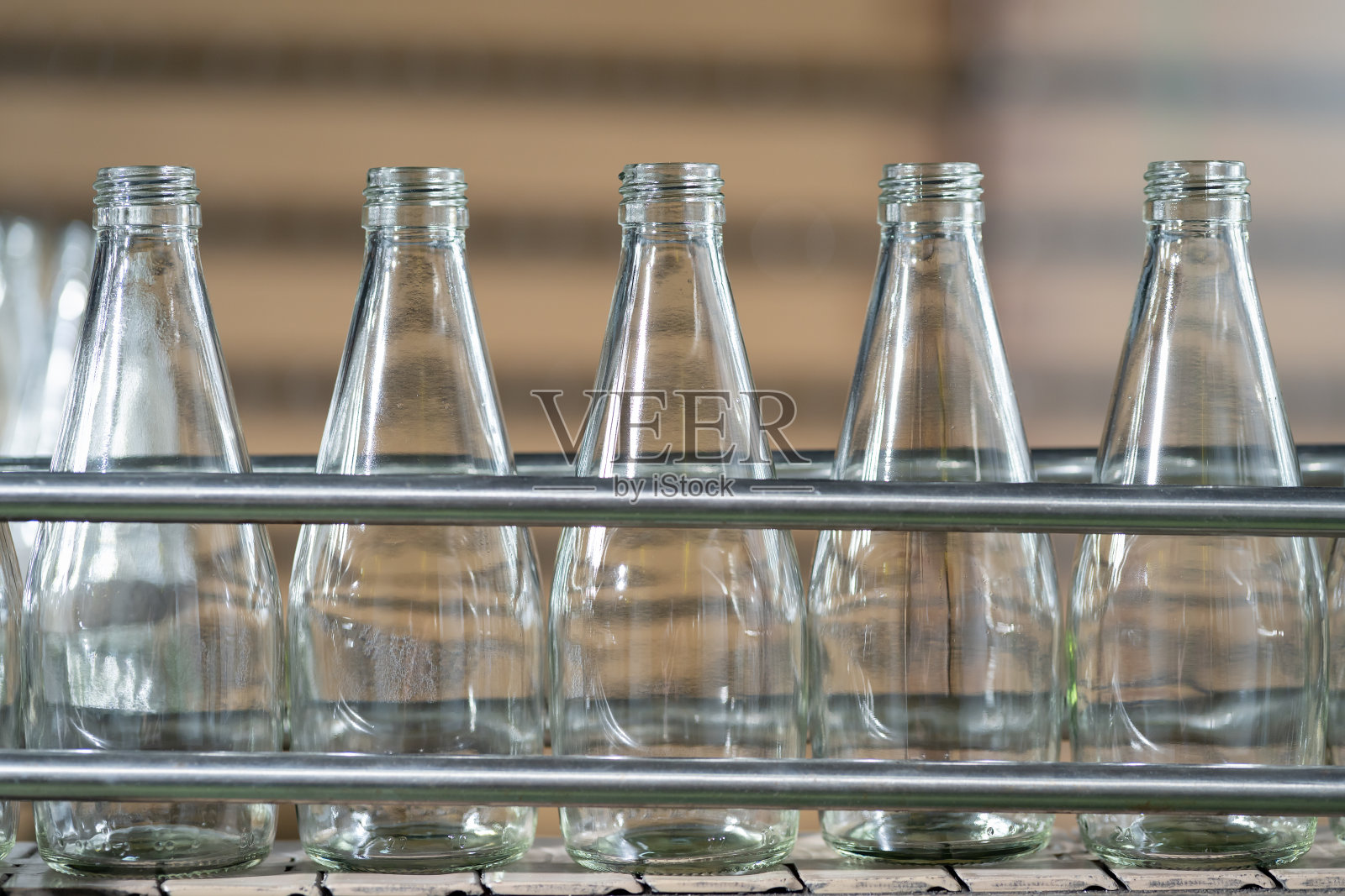 饮料工厂传送带上的果汁产品瓶。灌装生产线用于加工罗勒籽和水果装瓶。食品、健康和饮料行业照片摄影图片