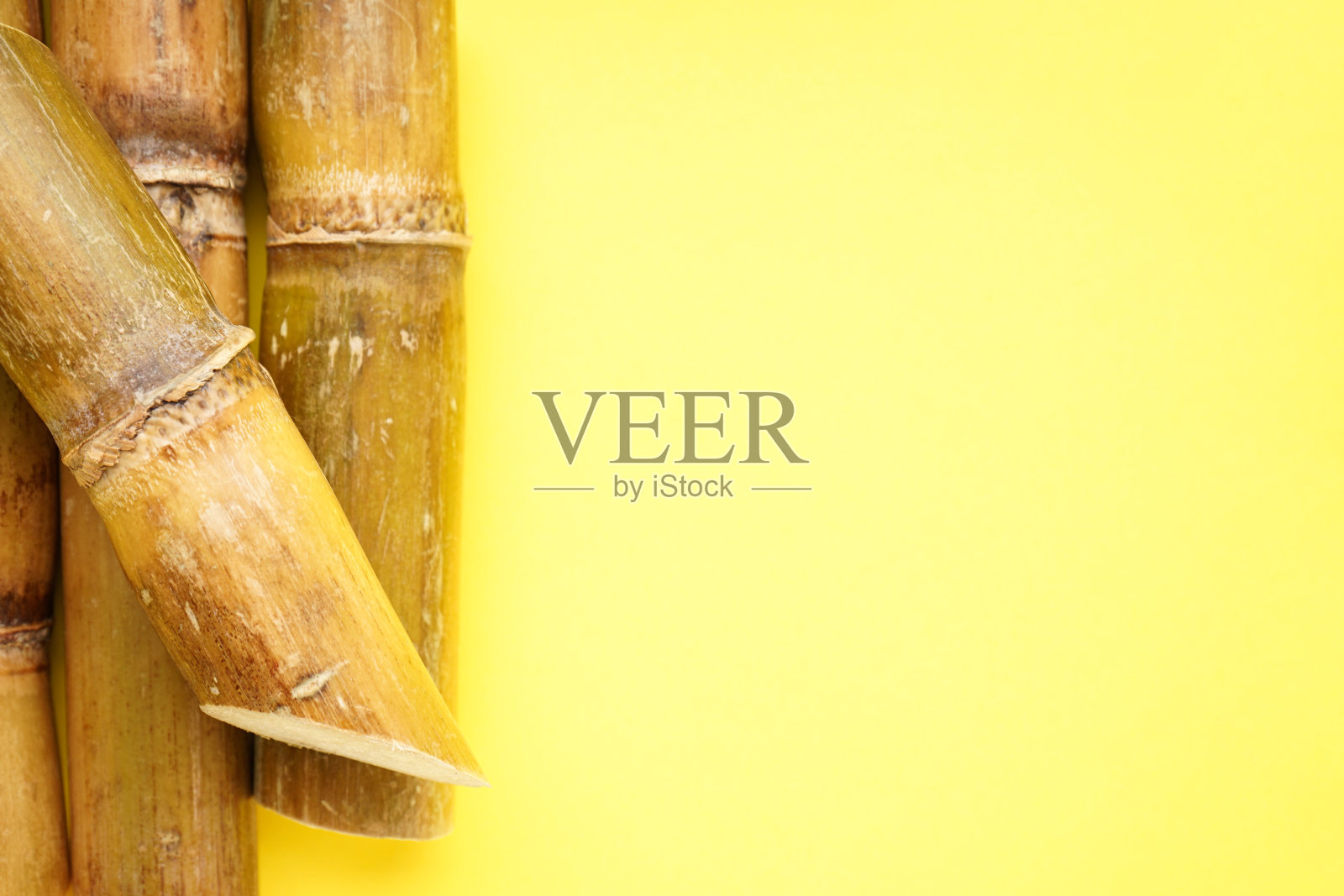 黄色背景的甘蔗配上文字空间，特写。平的。照片摄影图片