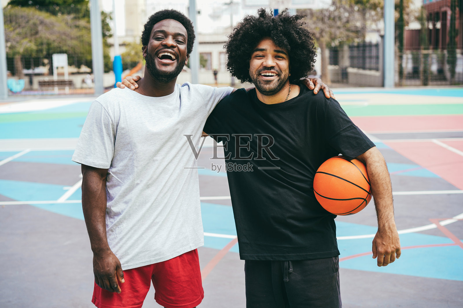 非洲朋友在户外打篮球-专注于左男人的脸照片摄影图片