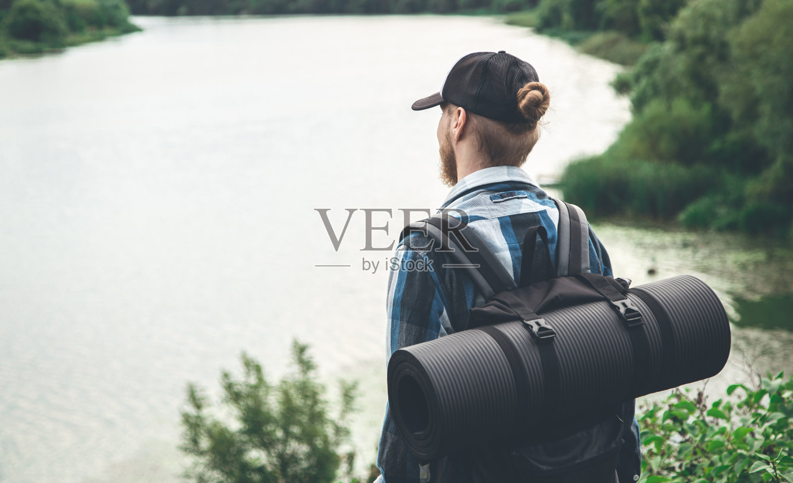 男性旅行者与背包和卡里马特在自然，背影。照片摄影图片