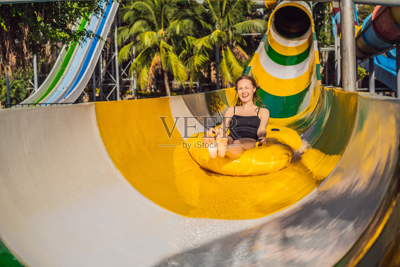 快乐的女人从滑梯上滑下来照片摄影图片