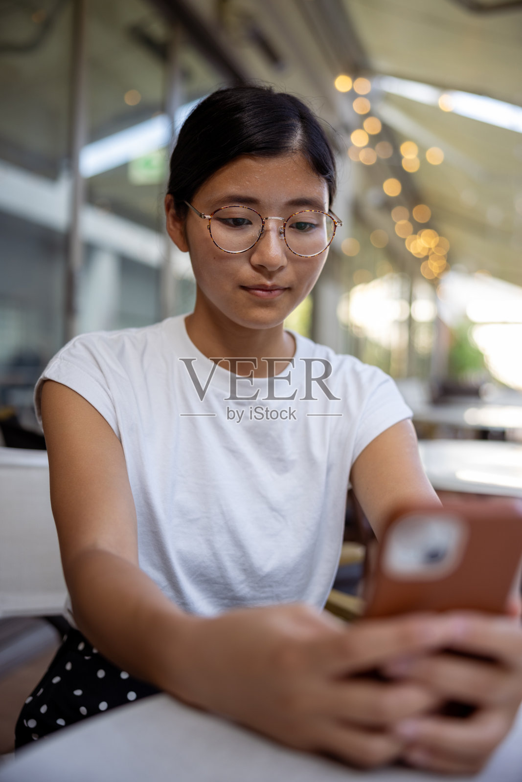 年轻女子在户外咖啡馆使用智能手机照片摄影图片