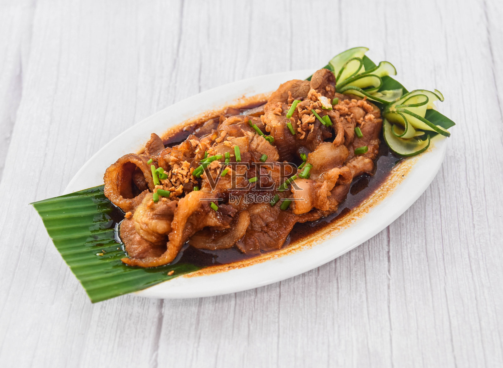 猪肉Bistek Tagalog在盘子孤立的灰色木制背景的快餐的侧面视图照片摄影图片