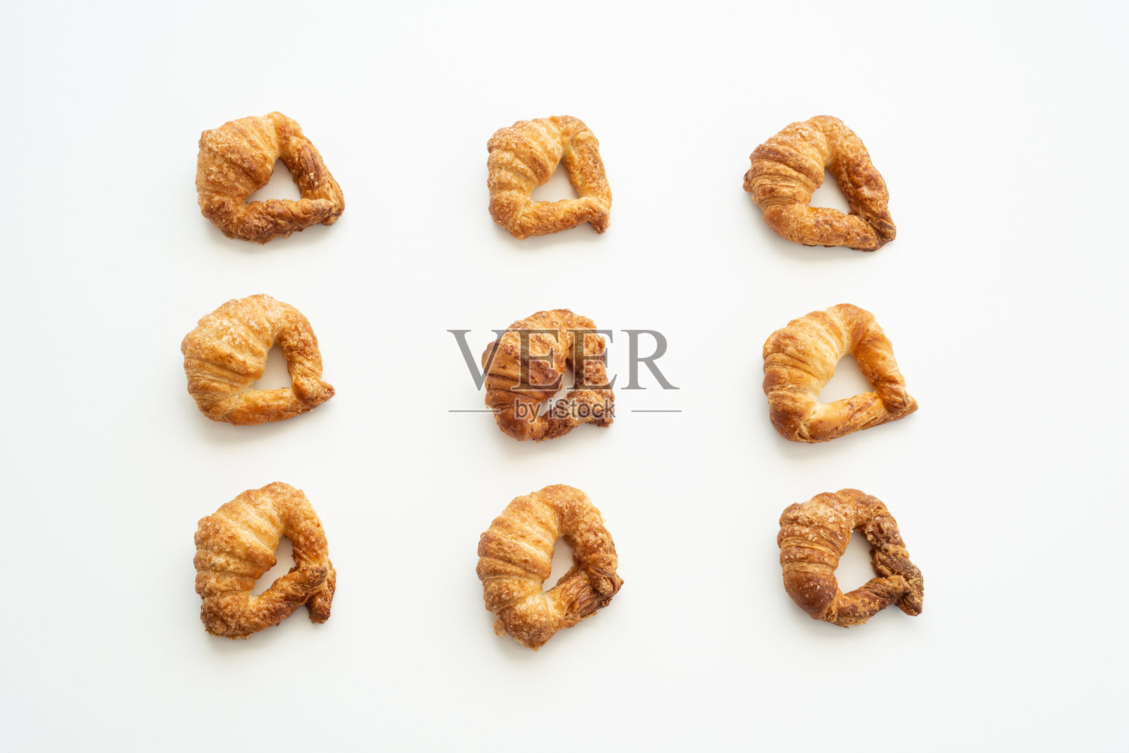 白底自制牛角面包的图案。早餐flat-lay。照片摄影图片