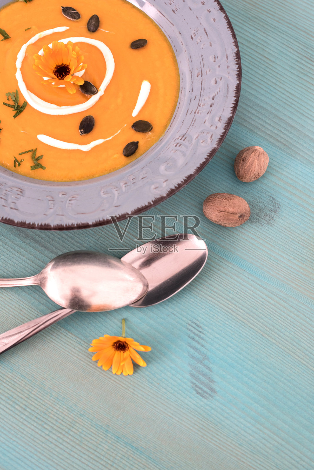 美味的南瓜汤，牛奶和南瓜籽，蓝色木制背景照片摄影图片