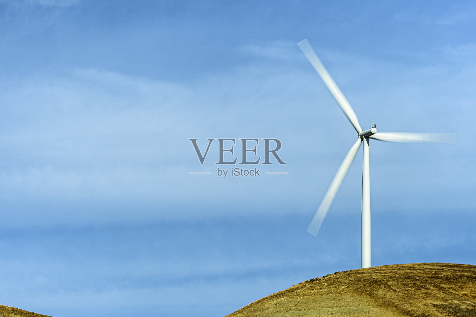 山丘上以云为背景的风力涡轮机照片摄影图片