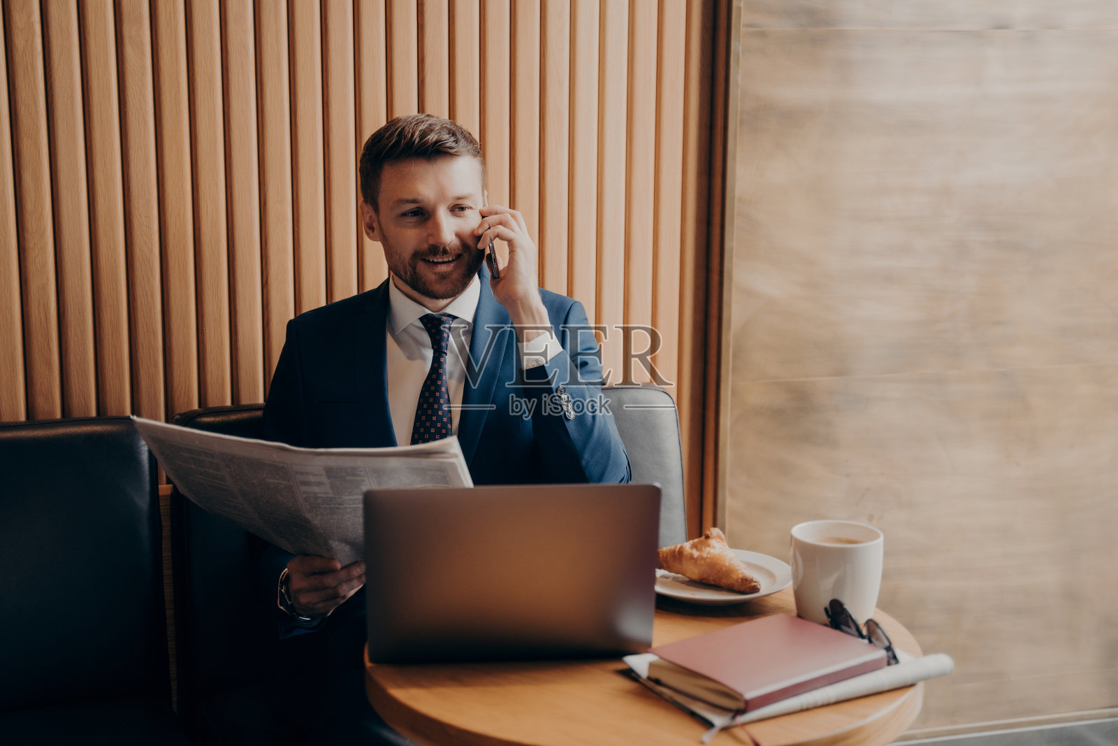 老板看完新闻后打电话，坐在咖啡馆里照片摄影图片