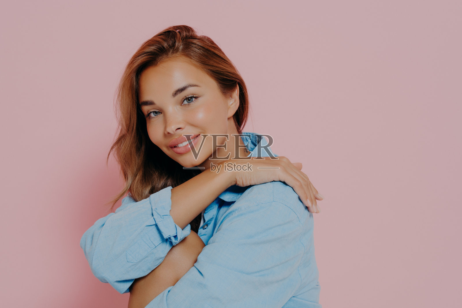 迷人的女士与美丽的微笑在粉红色的背景照片摄影图片