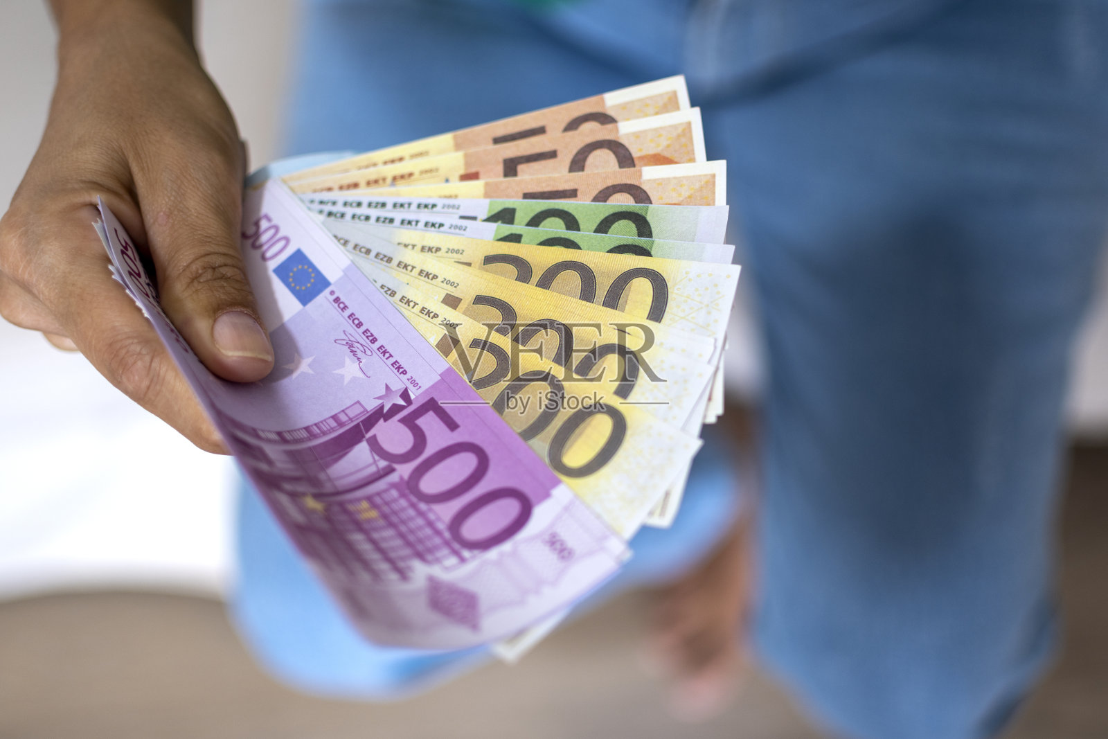 女人手里拿着钱。现金以欧元支付或兑换。女性用欧元钞票计算工资。存钱，取银行存款。欧洲单一货币。照片摄影图片