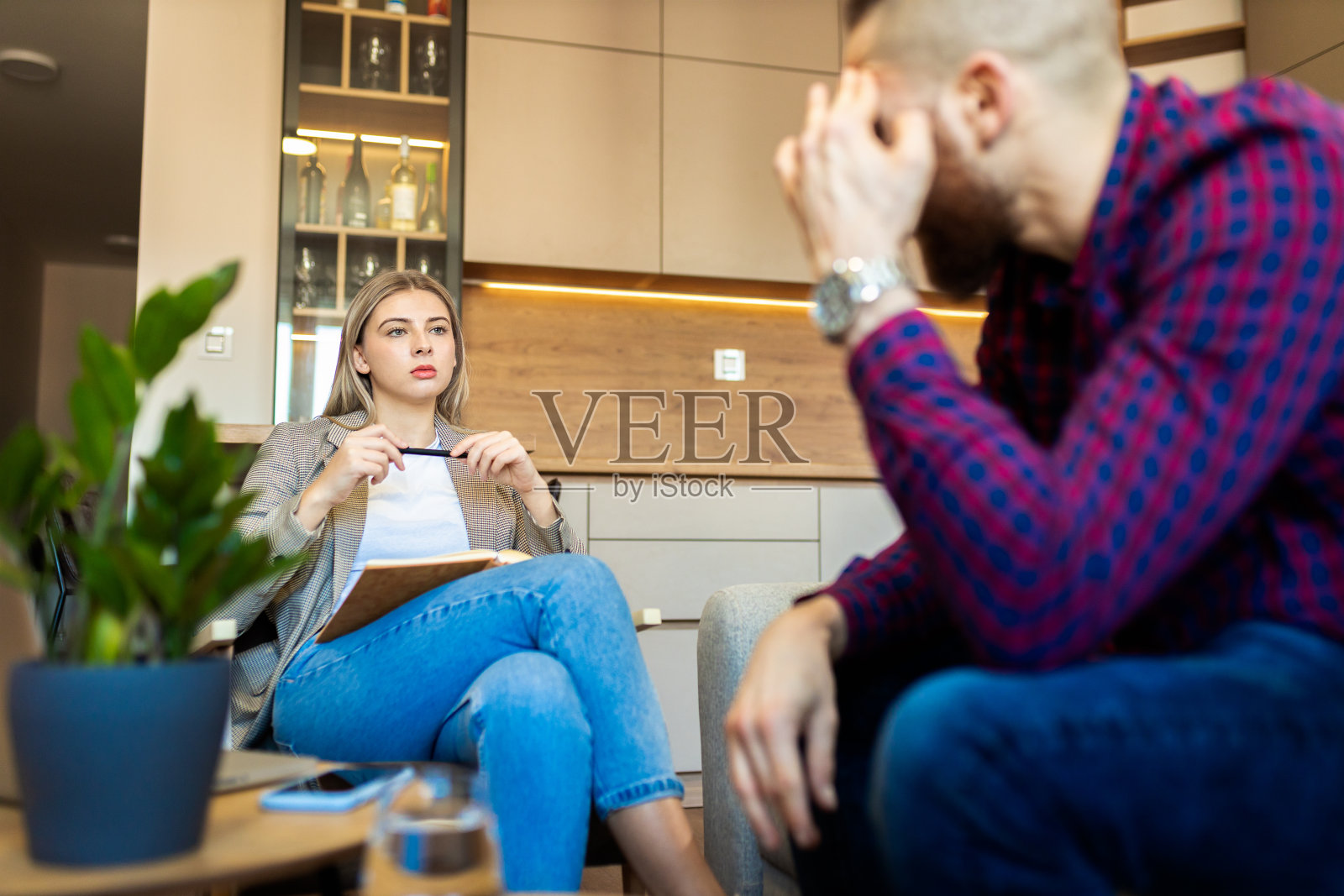 一位女性心理学家在治疗期间与一位年轻女士交谈。照片摄影图片