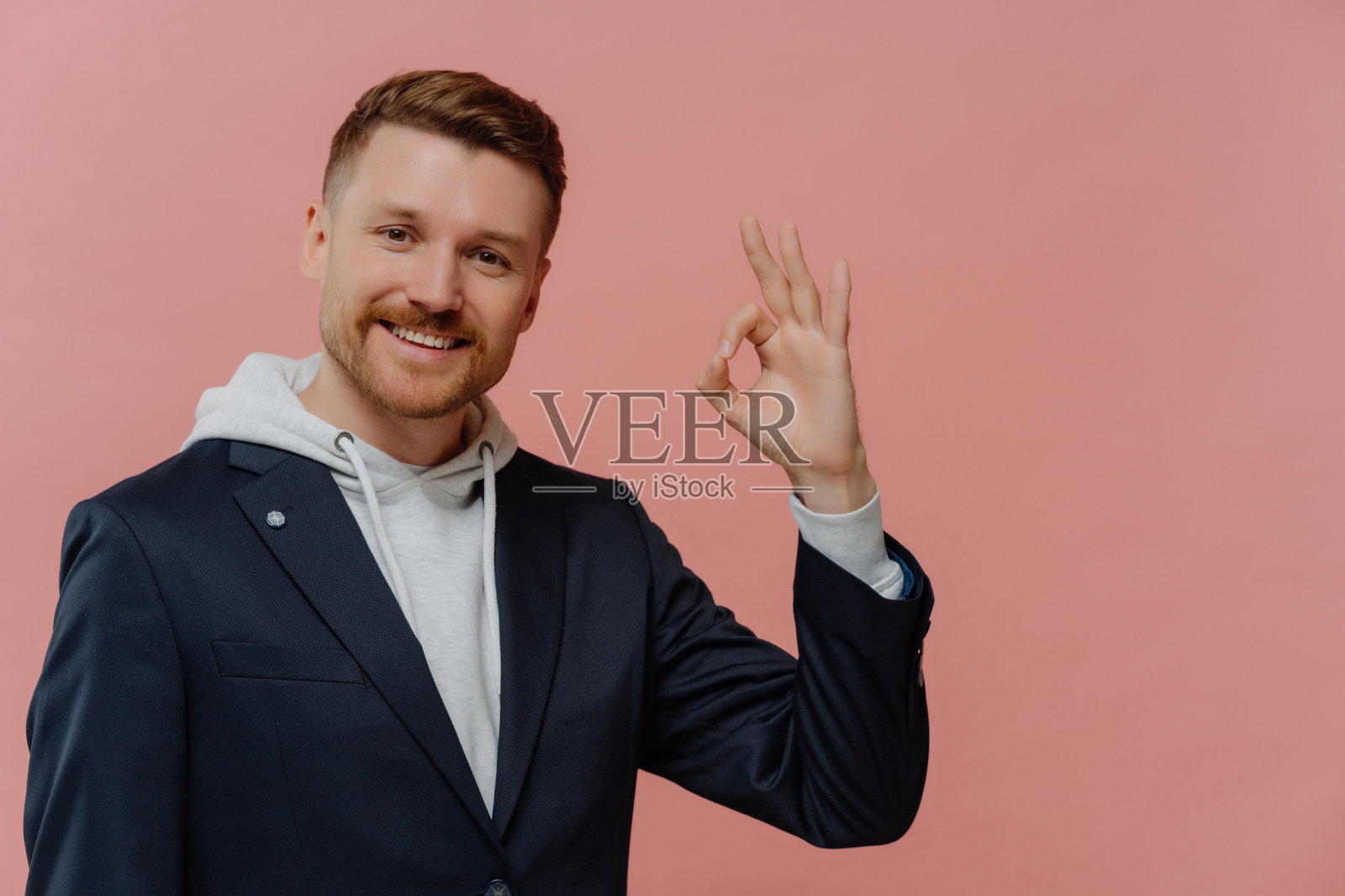 开朗的人显示ok标志和微笑孤立在粉红色的墙照片摄影图片