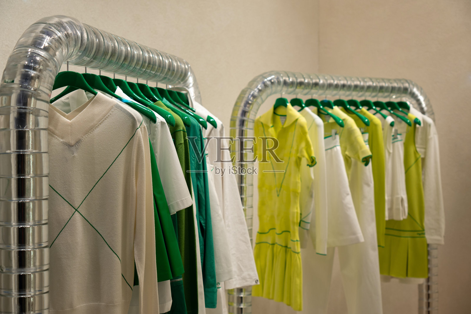 浅景深。一家精品店的衣架上挂着深绿色的时髦衣服照片摄影图片