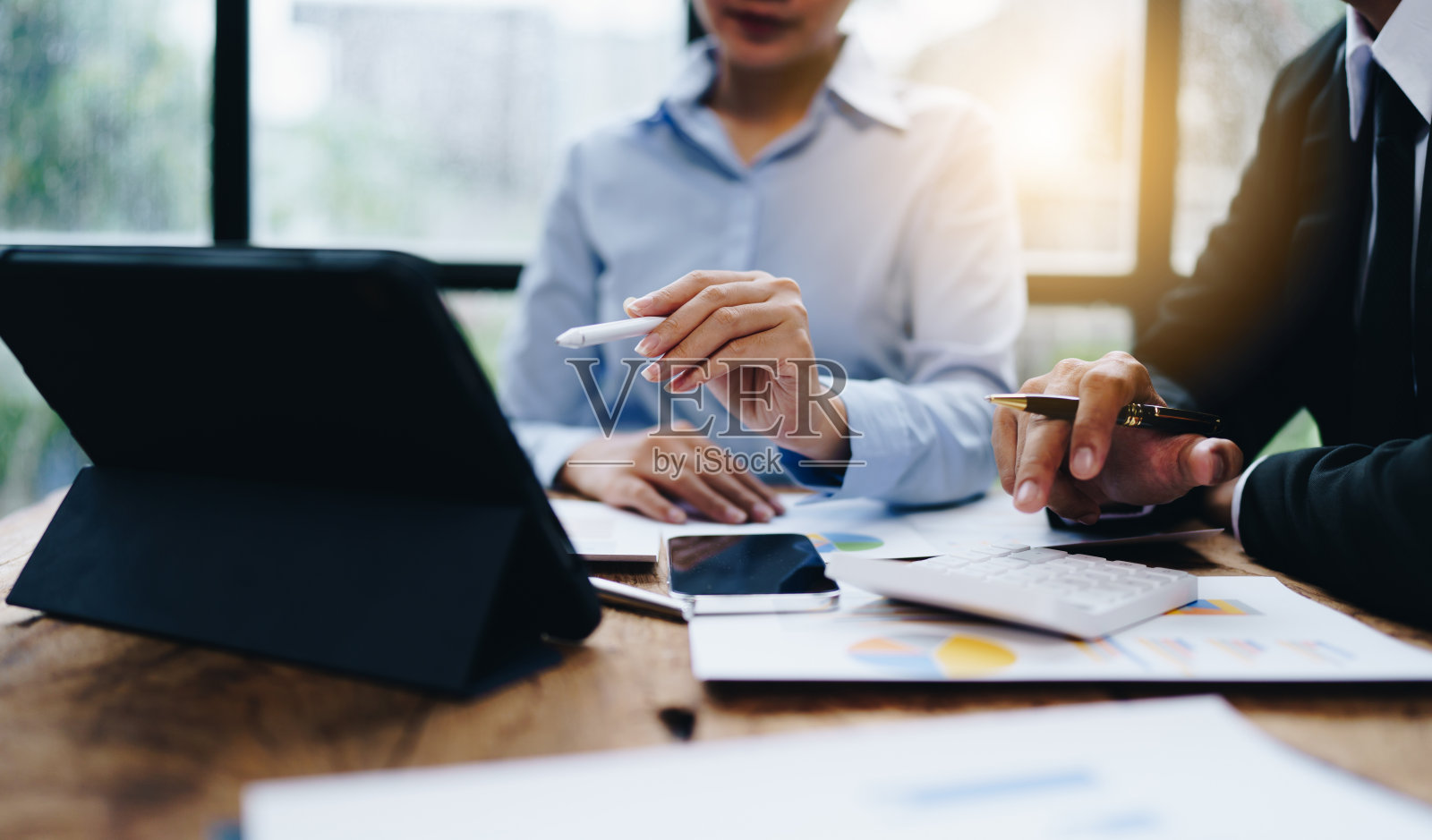 在办公室的预算会议上，业务伙伴同事通过讨论财务规划图和公司预算来分析策略。照片摄影图片