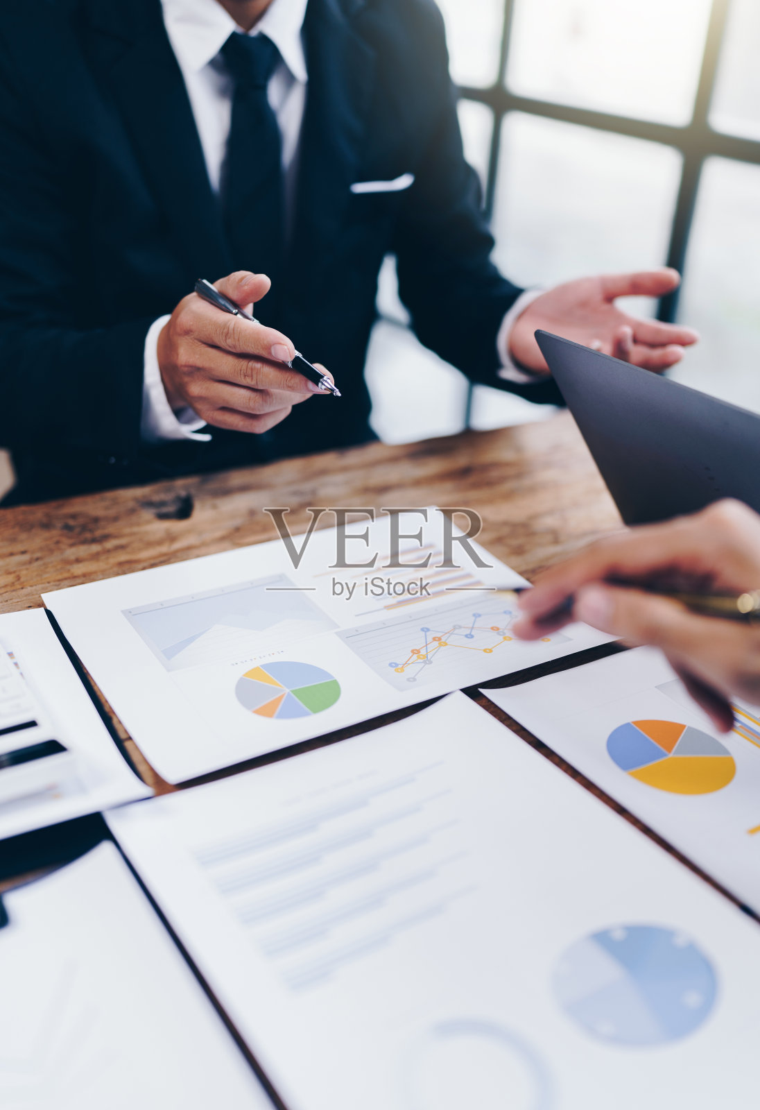 在办公室的预算会议上，业务伙伴同事通过讨论财务规划图和公司预算来分析策略。照片摄影图片