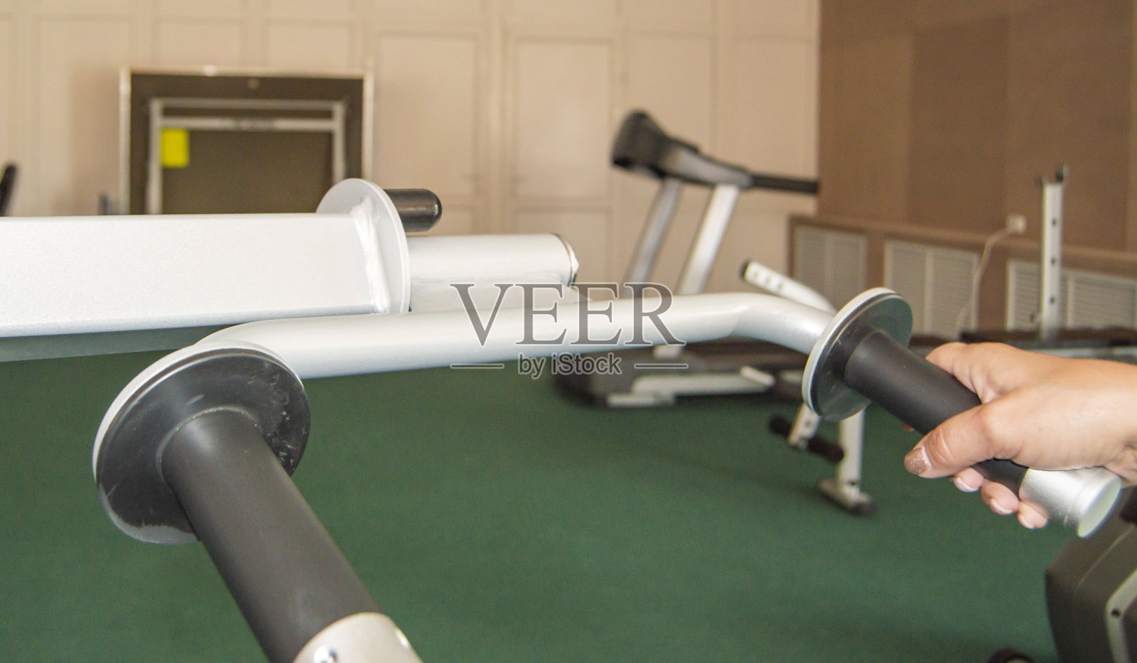 特写的跑步机手柄与成年女性的手在健身房的背景，健身课程的概念照片摄影图片