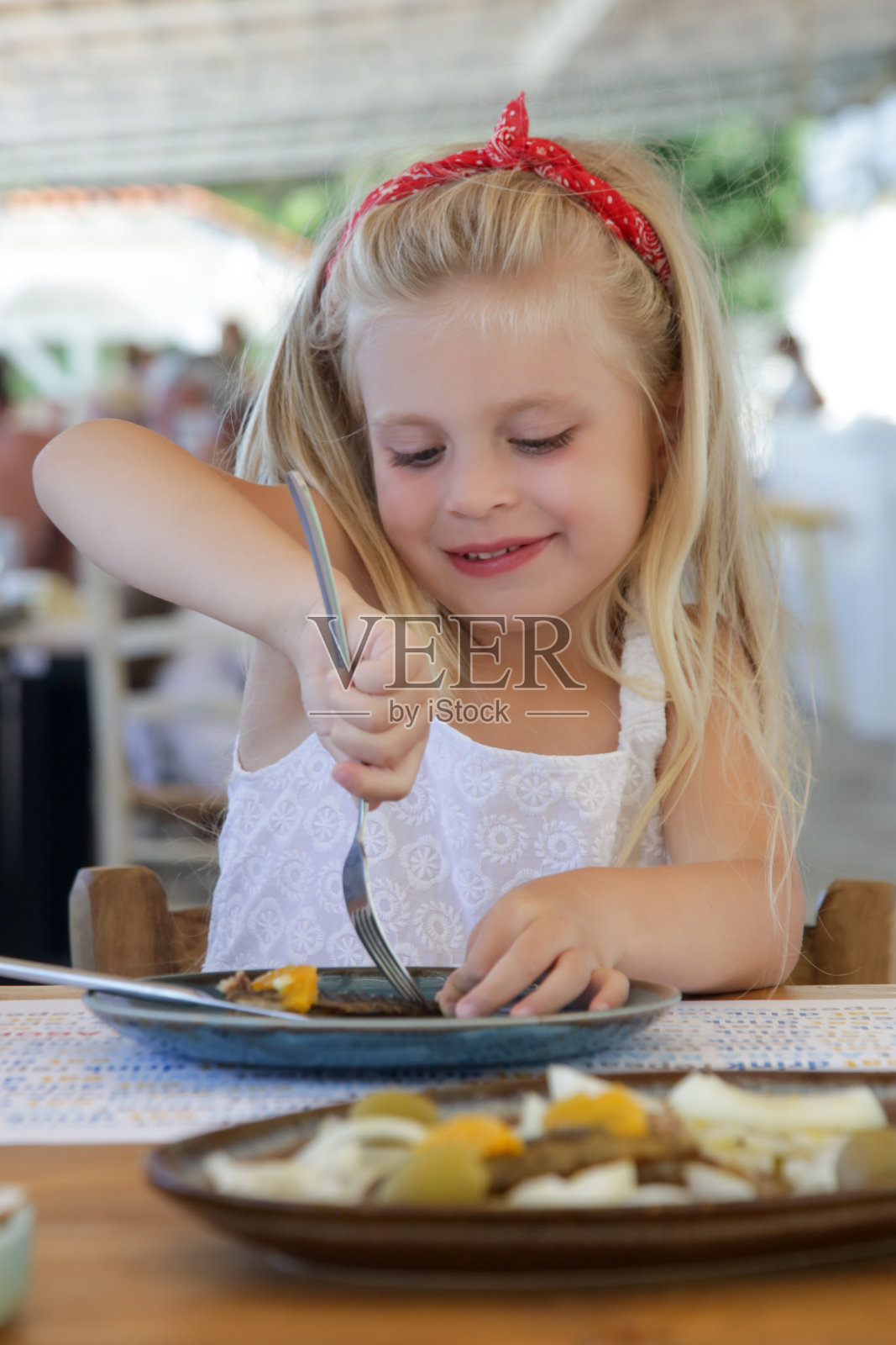 金发小女孩在餐厅吃饭照片摄影图片