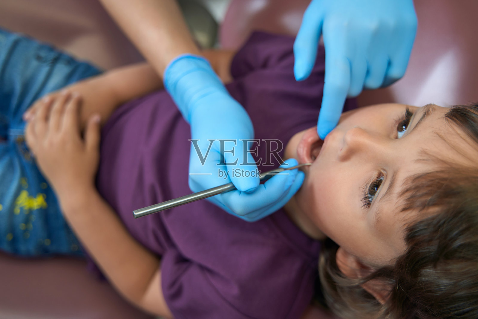 牙科医生用诊断工具检查女童牙齿照片摄影图片