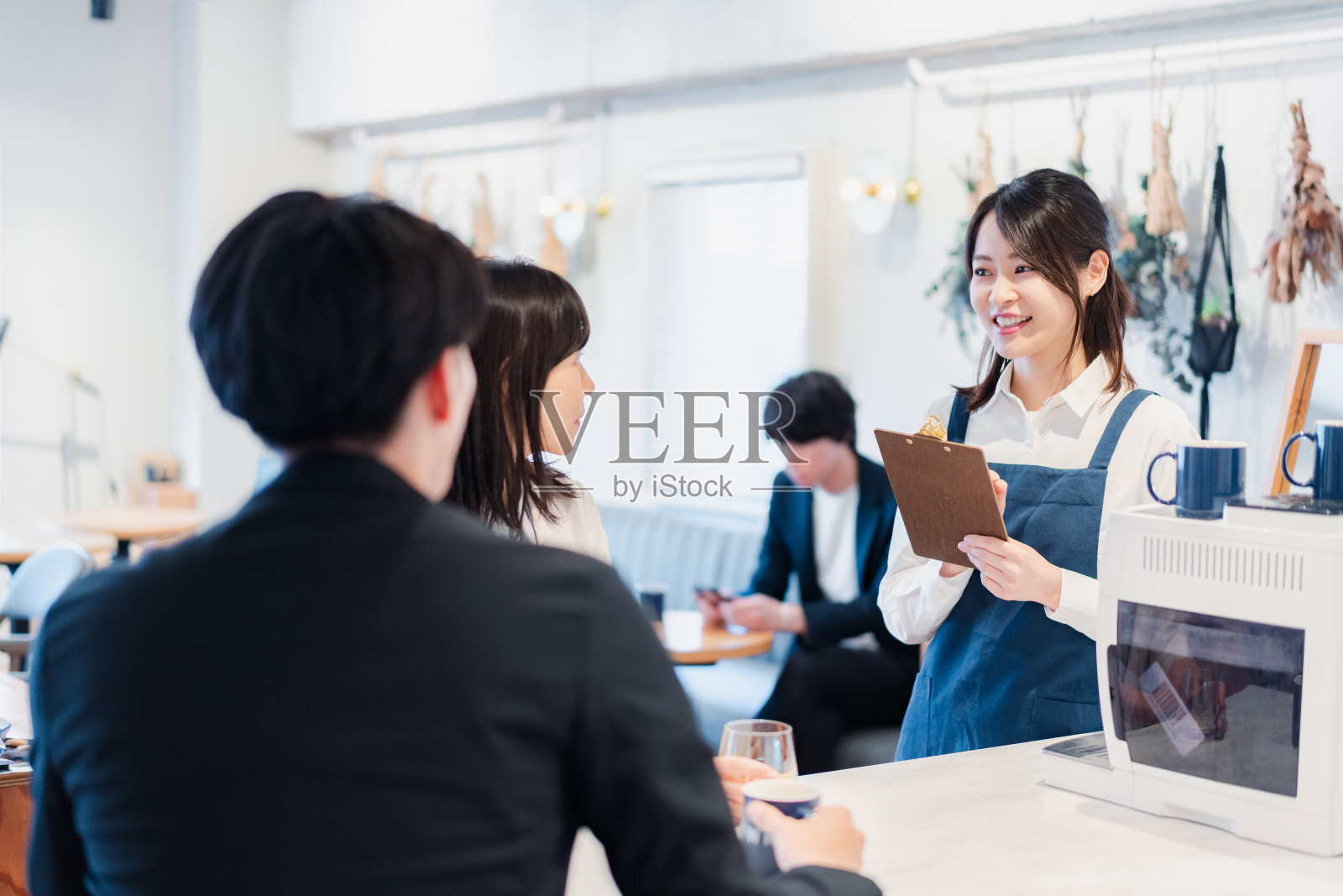 年轻的工作人员在咖啡馆点菜照片摄影图片