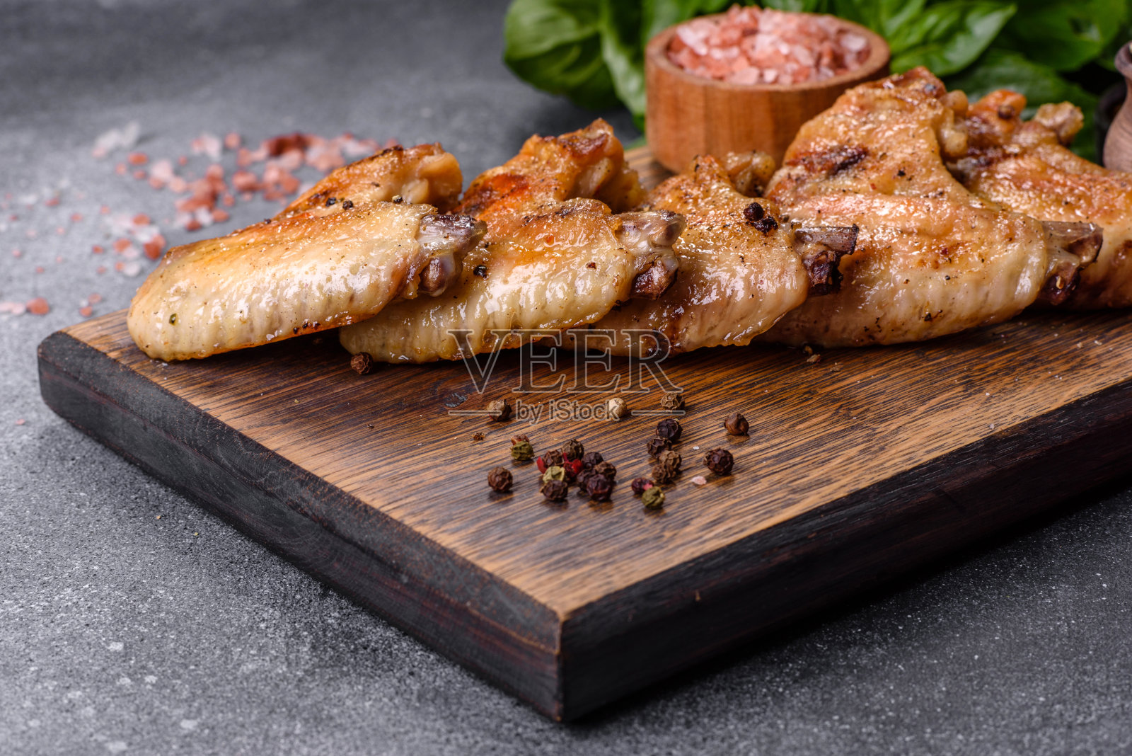 烤鸡翅配芝麻和酱汁放在木板上照片摄影图片