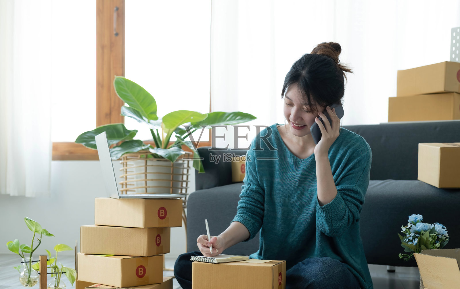 创业小企业中小企业，企业家业主使用智能手机或平板电脑接收和检查网上购买购物订单，准备包装产品的盒子。销售网络创意概念照片摄影图片