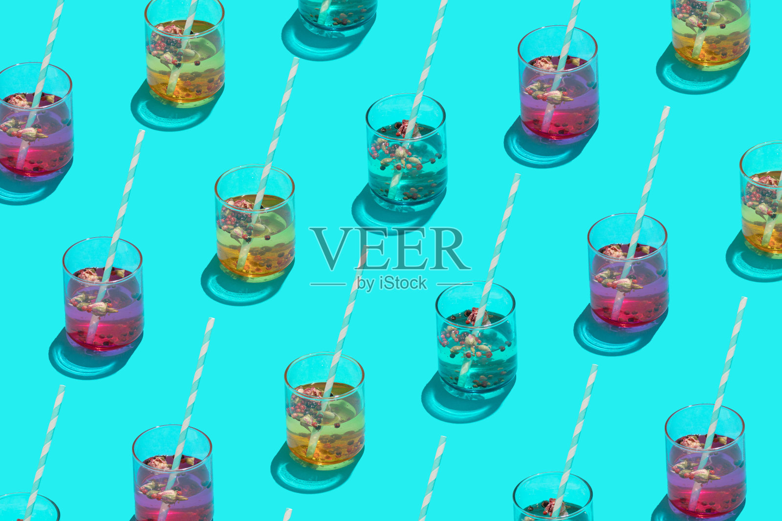 鸡尾酒彩色饮料杯与纸吸管图案的蓝色背景。夏天的模式。照片摄影图片