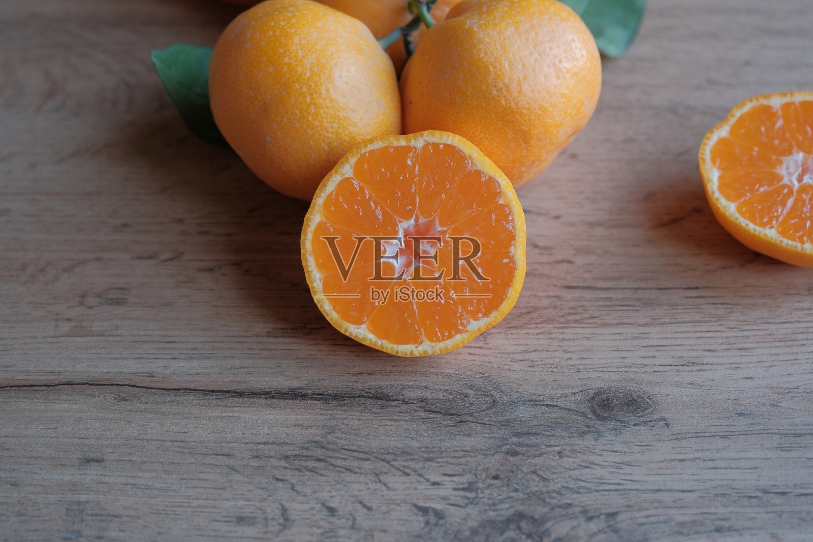 成熟多汁的橘子(普通话)。在灰色背景上切下橘红色的水果。照片摄影图片