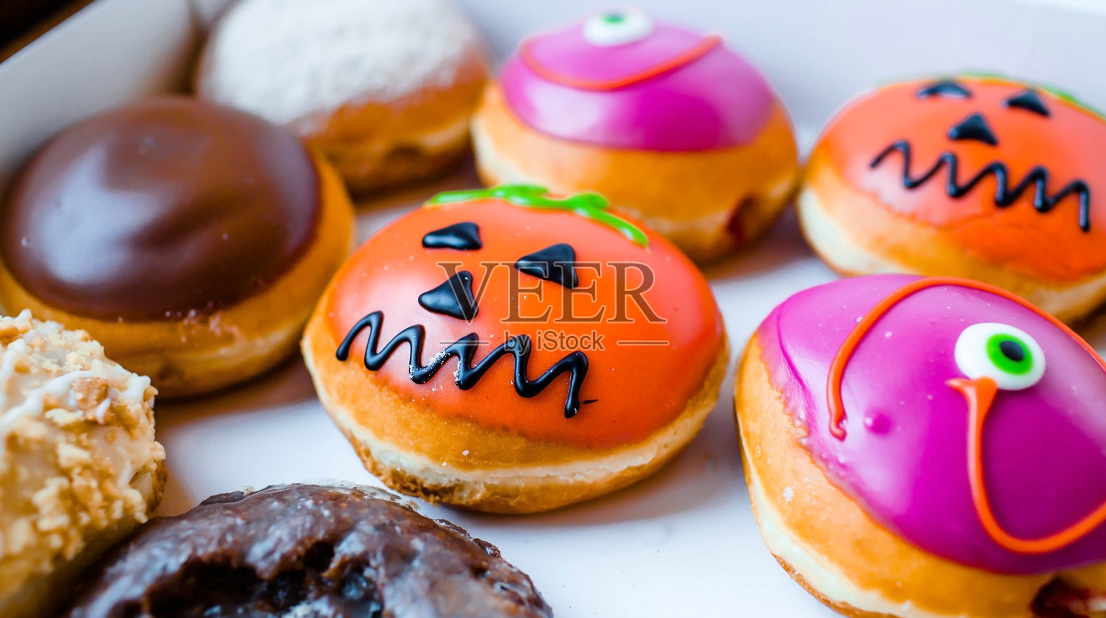 为万圣节装饰的美味多彩甜甜圈。从上面看。照片摄影图片