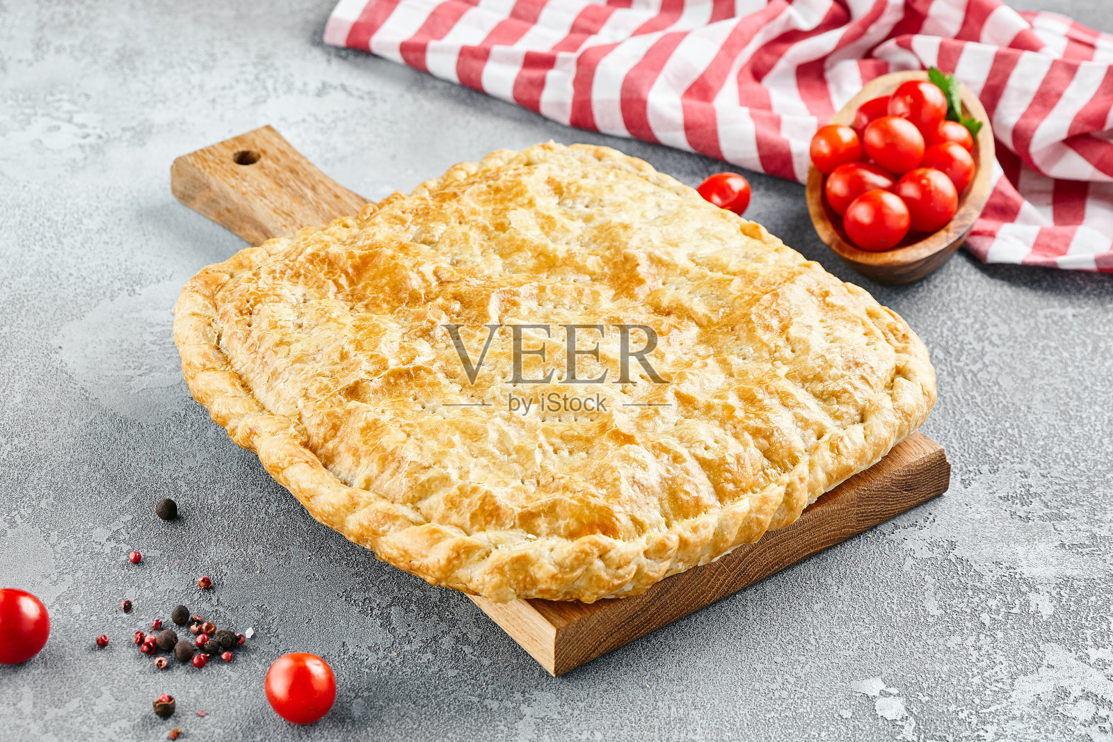 用泡芙、肉末和奶酪做成的封闭派。灰色石头背景上的肉饼。石桌上质朴风格的羊肉馅饼。木版面点造型，美观大方。照片摄影图片