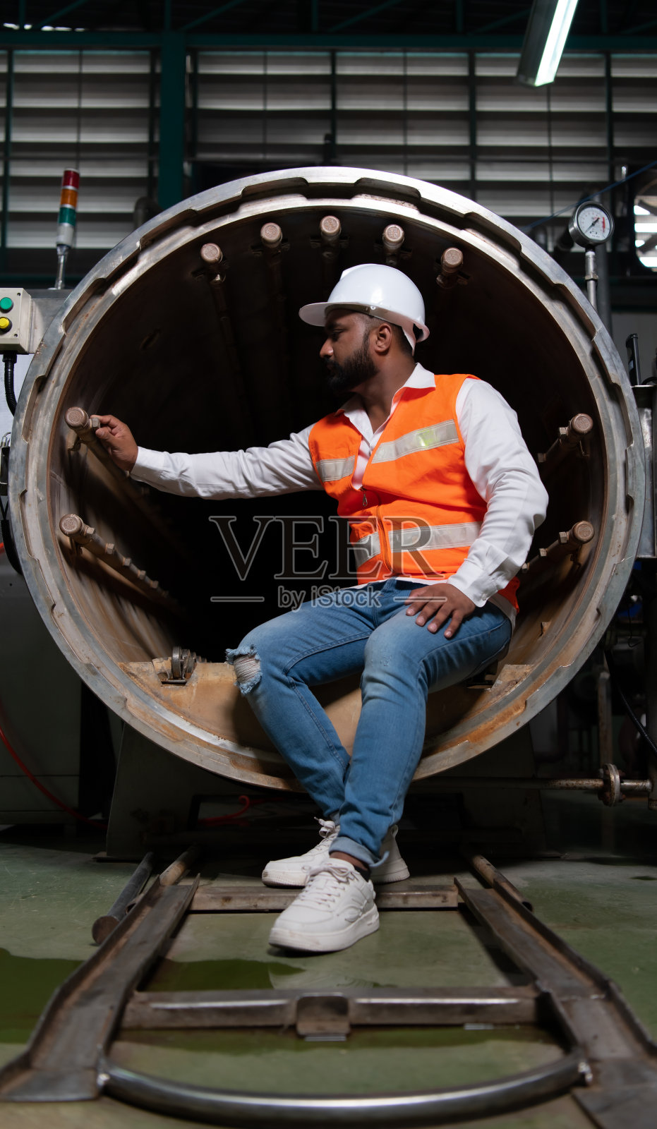 机械厂总工程师对灭菌机隧道进行检查。要检查机器的工作状态，做好准备照片摄影图片