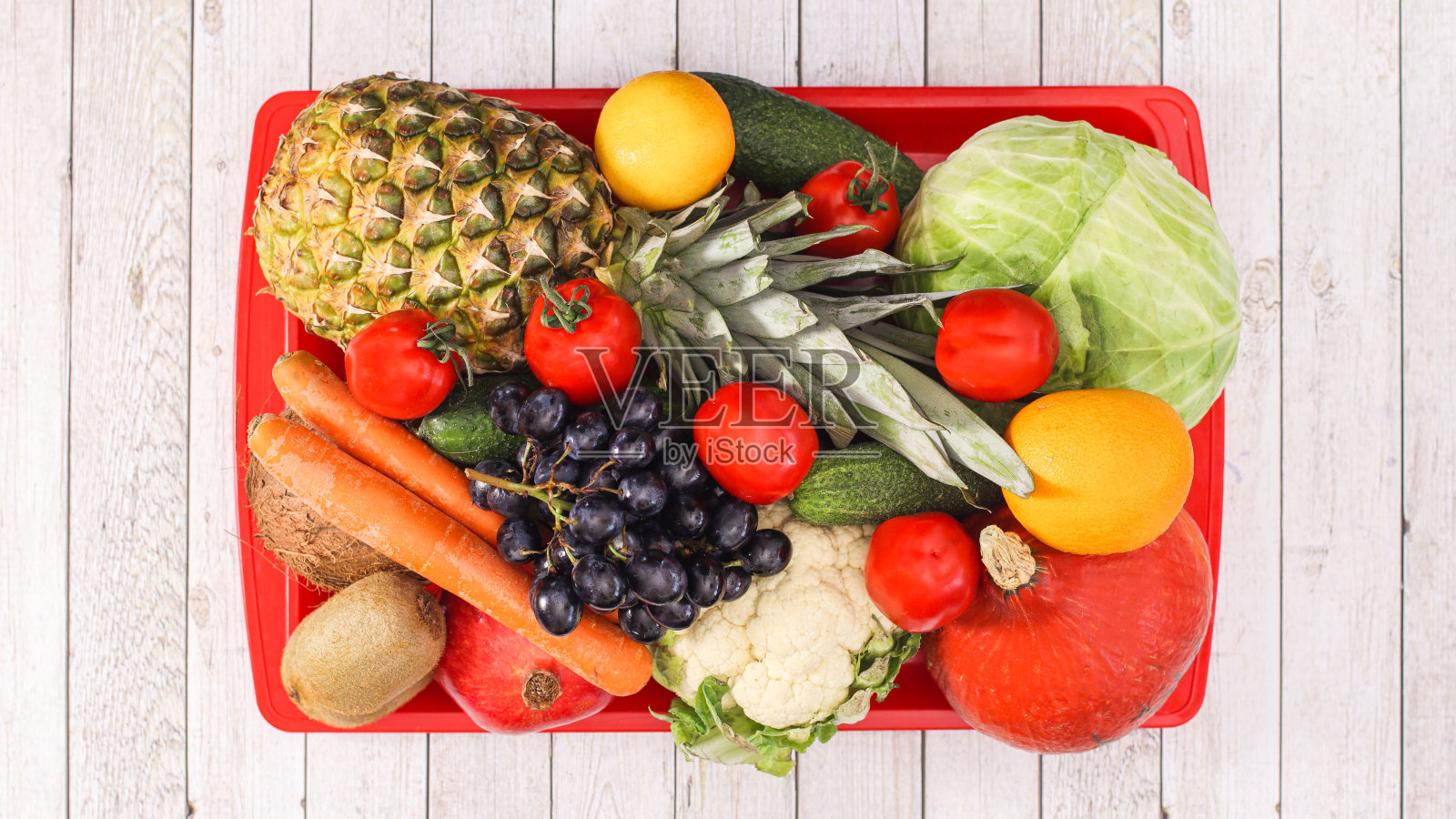 红色的盘子装满了健康的食物。新鲜的水果和蔬菜在木桌上。平躺照片摄影图片
