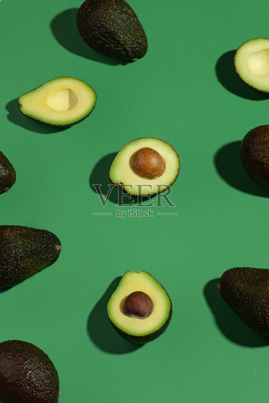 绿色的底色，整个和切好的牛油果片照片摄影图片