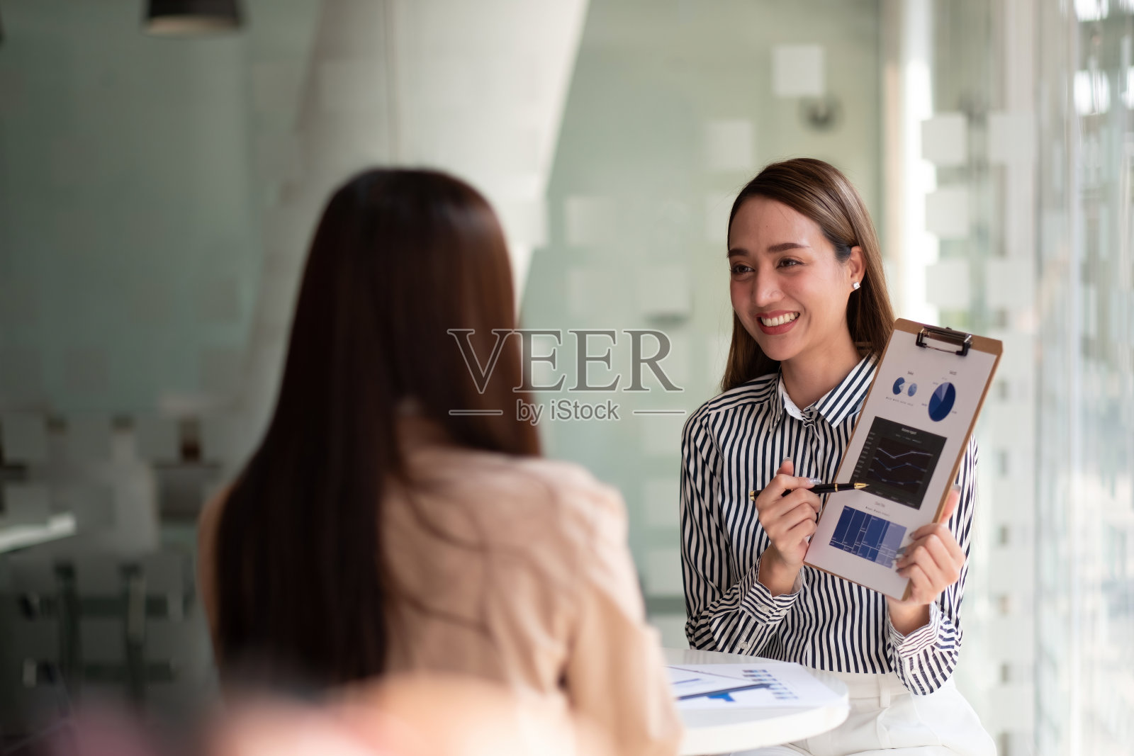 商务人士在办公室开会。手持文件与财务统计讨论分析报告数据图表财务团队合作成功职场策略概念照片摄影图片