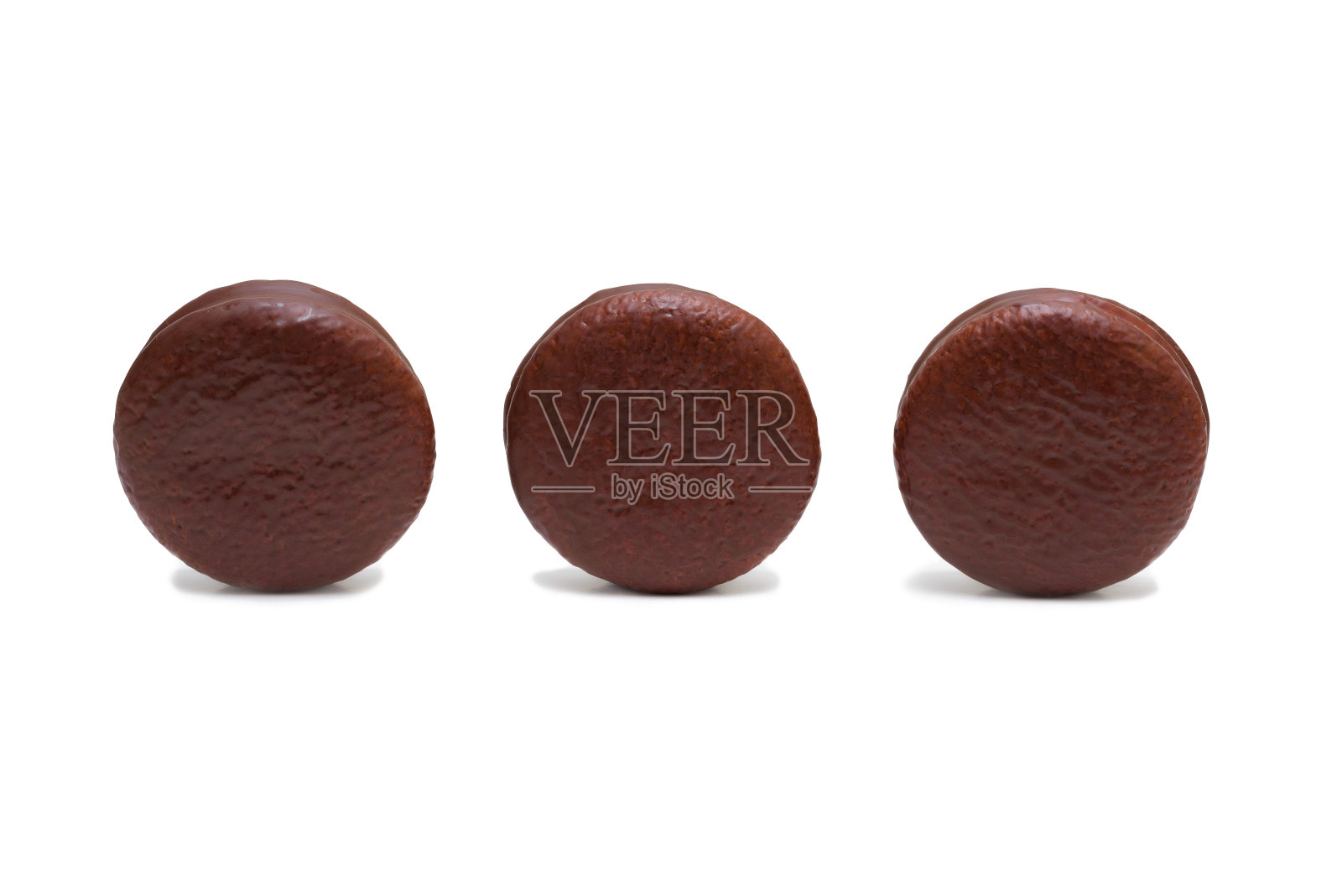 三个圆圆的饼干，在白色的背景上用巧克力烤焦。空间的文本。照片摄影图片