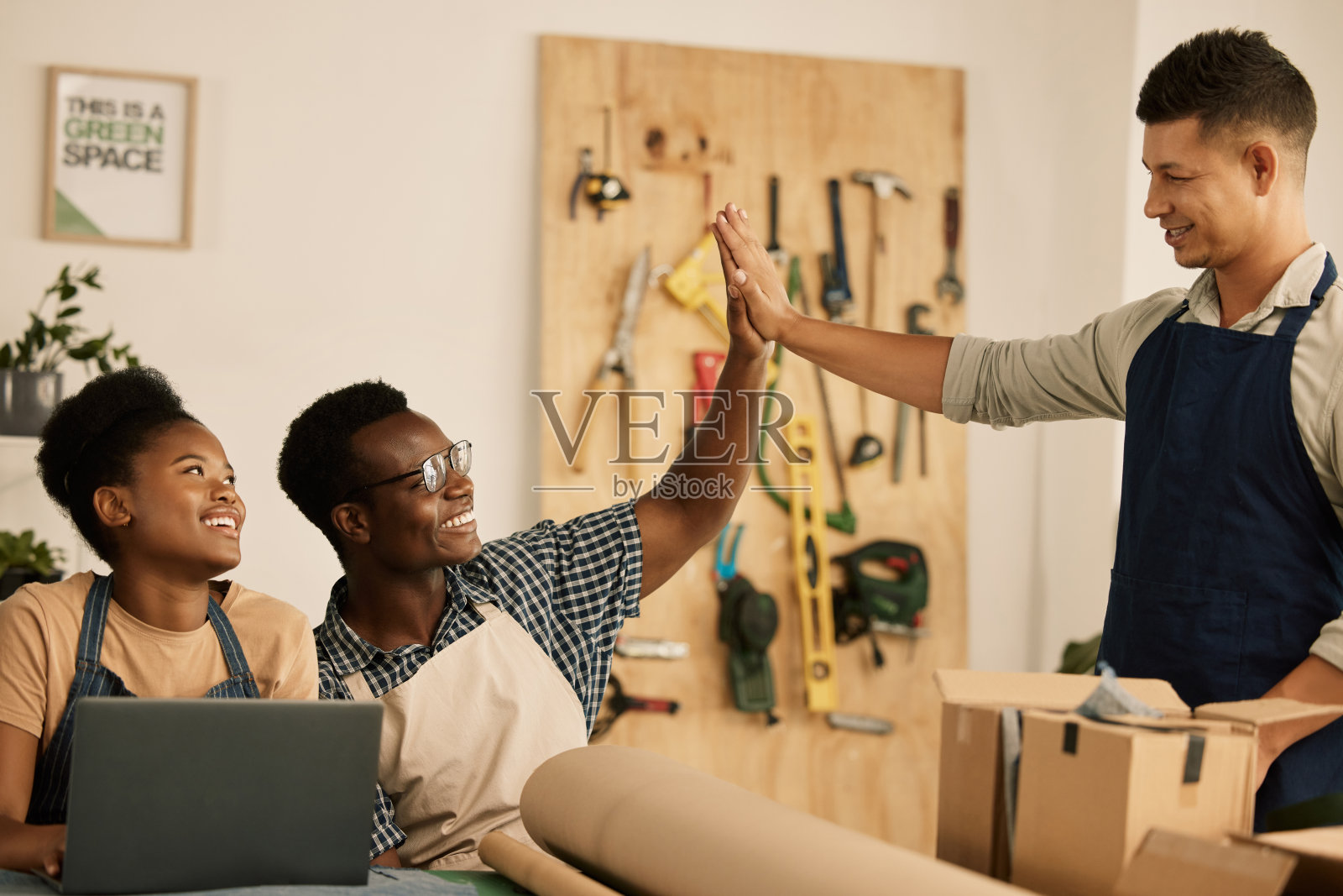 团队合作和成功或庆祝与击掌。时尚，设计和风格，多元化和专业的团队成员在一个创意工作室工作。创造新潮、时尚、新颖的衣服照片摄影图片