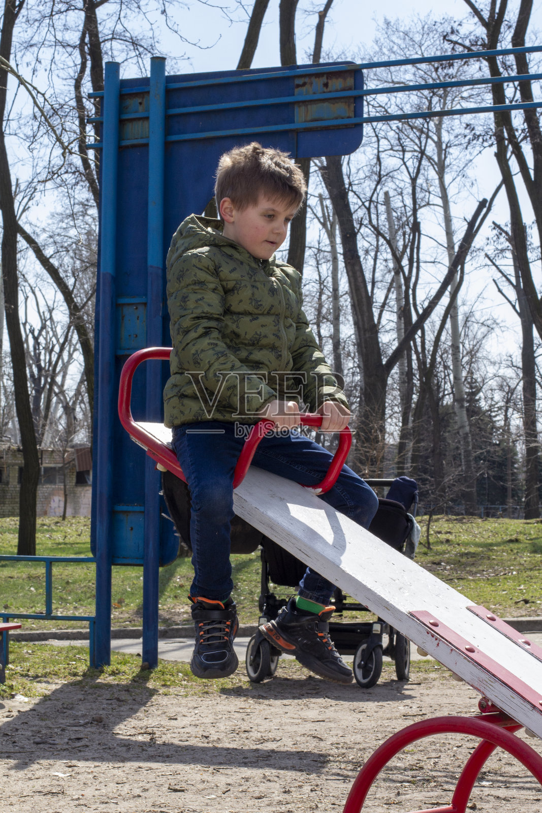 小男孩在操场上荡秋千玩得很开心。快乐的孩子喜欢荡秋千。儿童户外活动休闲。照片摄影图片
