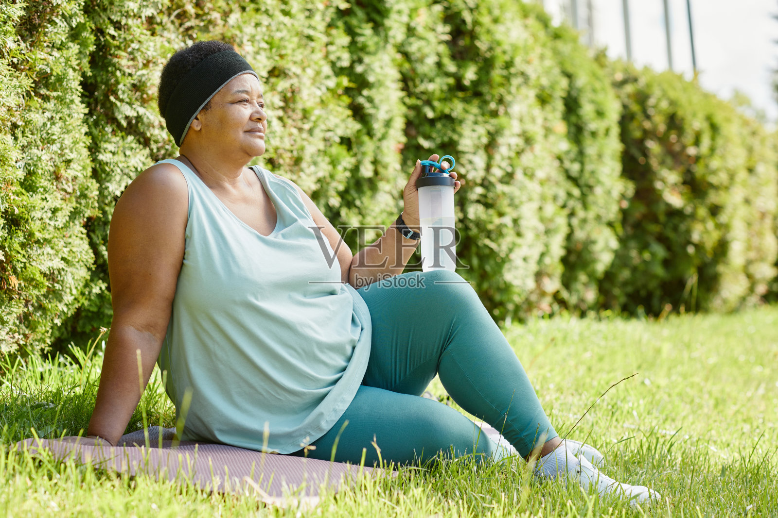 女性在户外锻炼后躺在草地上休息照片摄影图片