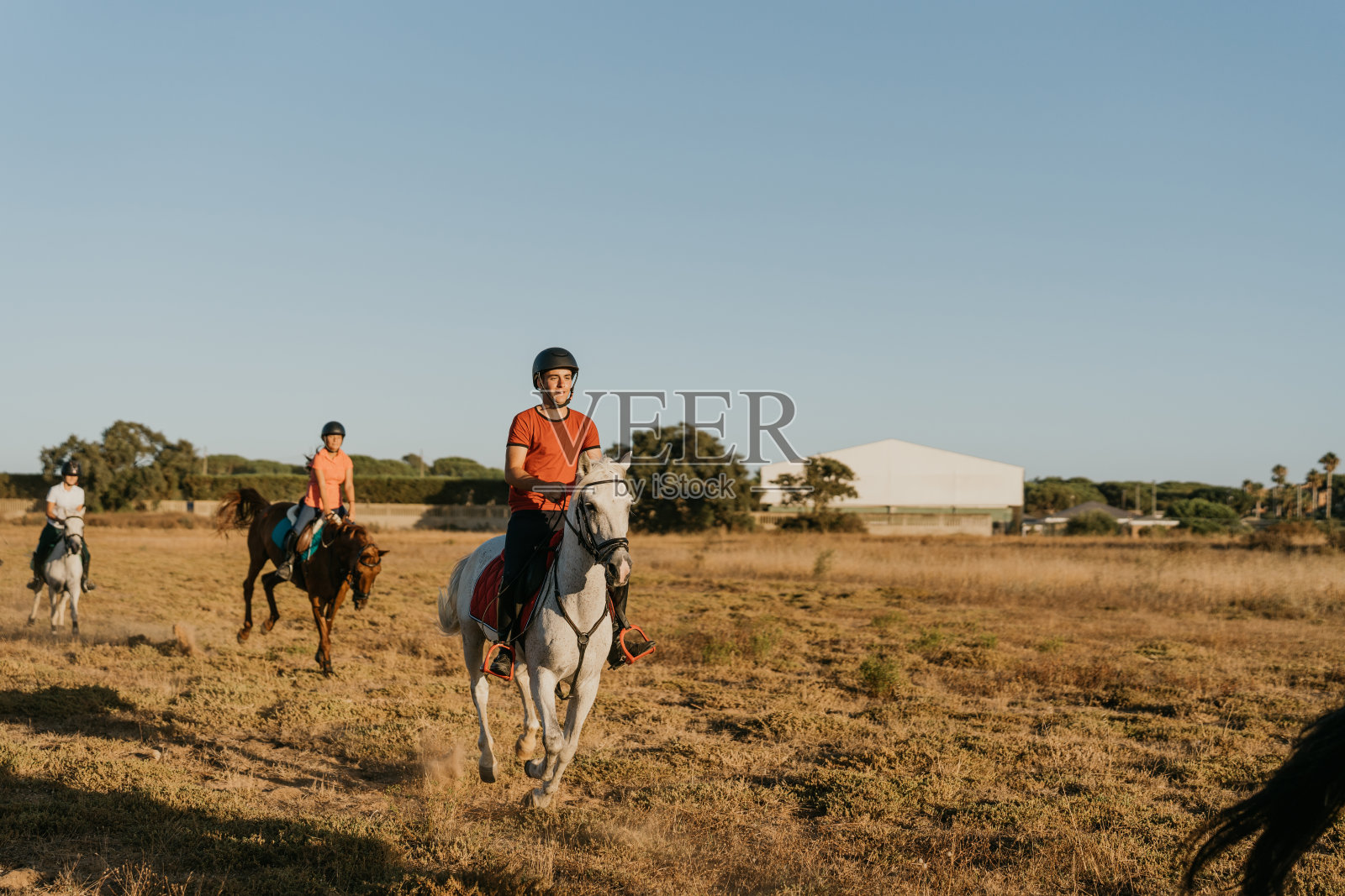 骑白马的红衣少年与同学照片摄影图片