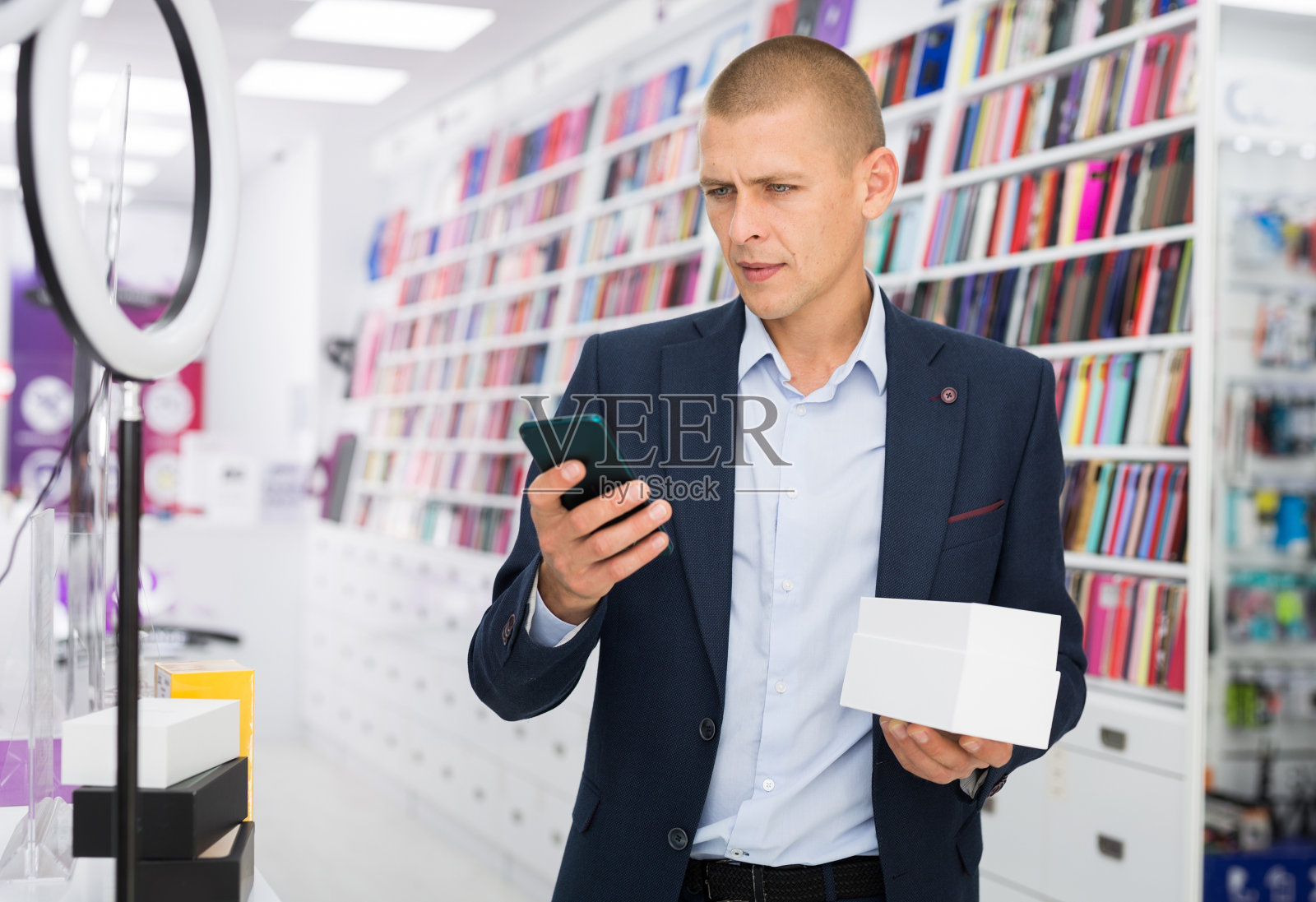 一名男子在电子商店挑选手机照片摄影图片