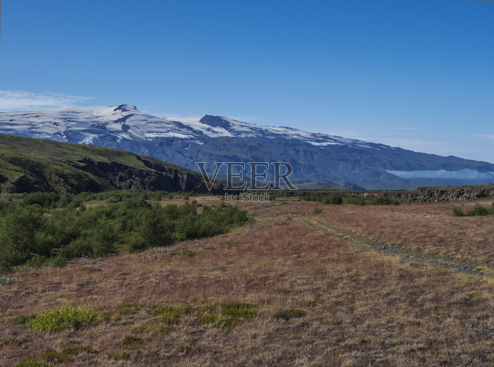 冰岛的景观有红草，桦树丛，绿色的山丘和埃亚菲亚德拉火山冰川。洛徒步旅行。冰岛Fjallabak自然保护区。夏天的蓝天照片摄影图片
