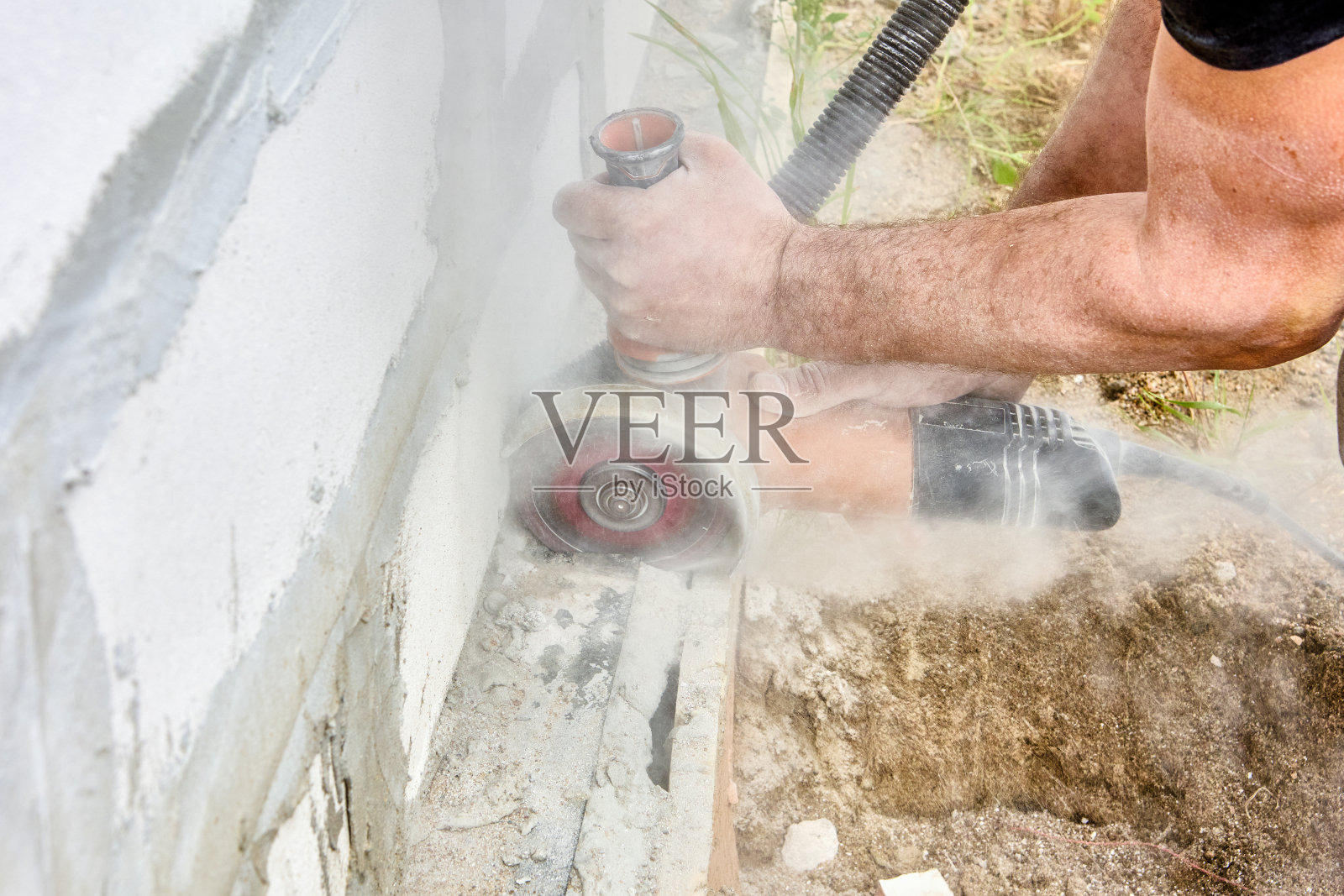 用角磨机切割砖石，用碳化硅砂轮切割混凝土的电动工具。照片摄影图片