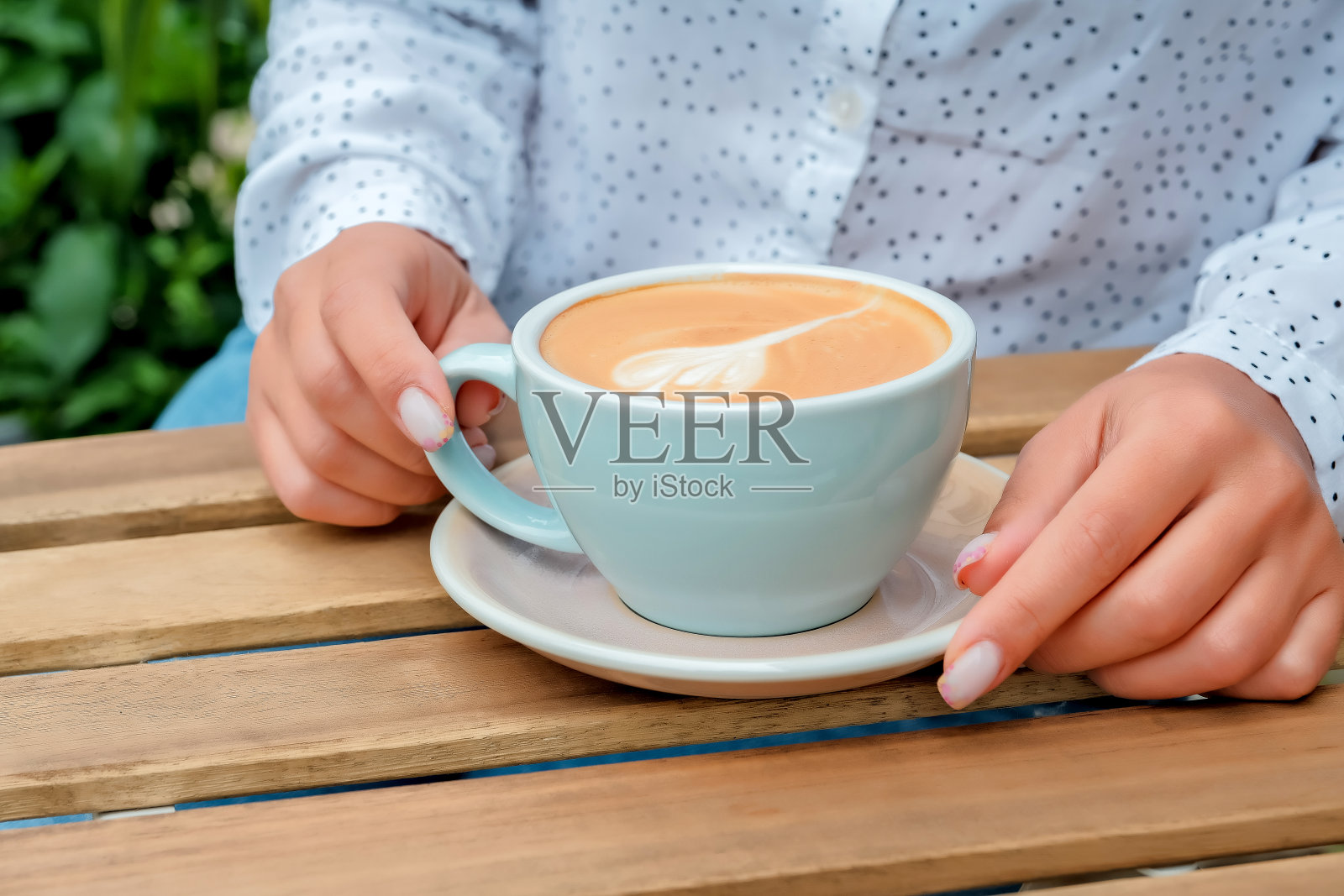 女性双手捧着一杯咖啡。一杯咖啡特写照片摄影图片