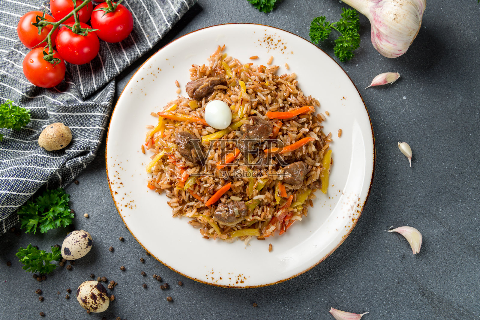 肉饭配牛肉，鸡蛋，胡萝卜放在漂亮的盘子上，灰色的桌面俯瞰照片摄影图片