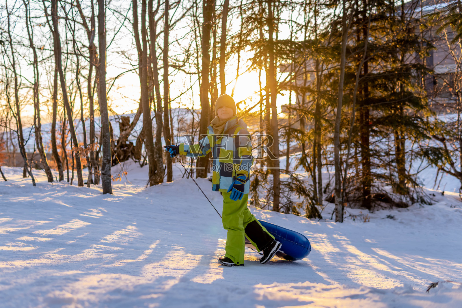 孩子们坐着雪橇从山上滑下来照片摄影图片