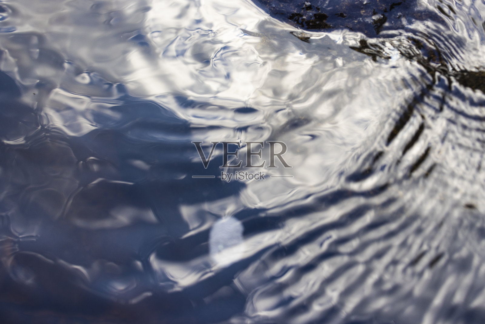 流水的水面，与天空的倒影。照片摄影图片