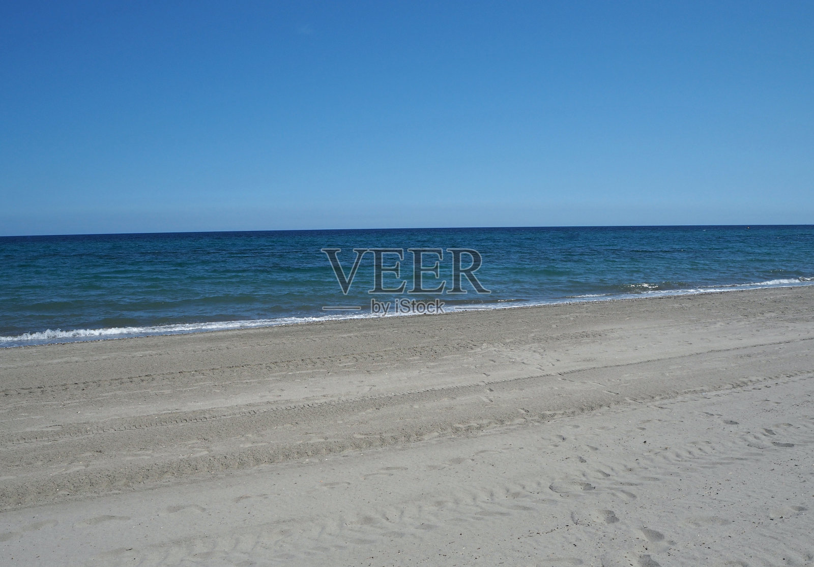 干净空旷的沙滩，蔚蓝的天空，平静的大海照片摄影图片