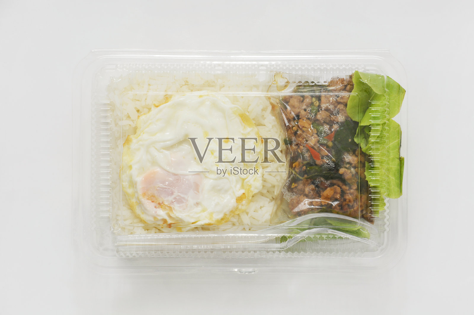 茉莉花饭用香辣猪肉炒香，再加上煎蛋，装在透明的塑料盒里，即食照片摄影图片