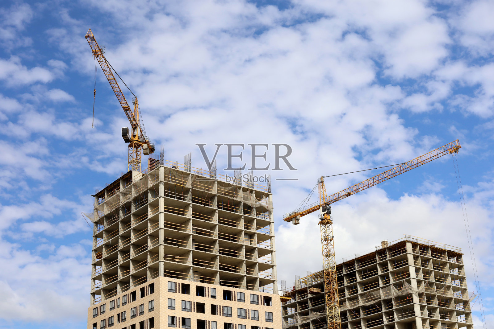 蓝天白云下的塔吊和未完工建筑照片摄影图片